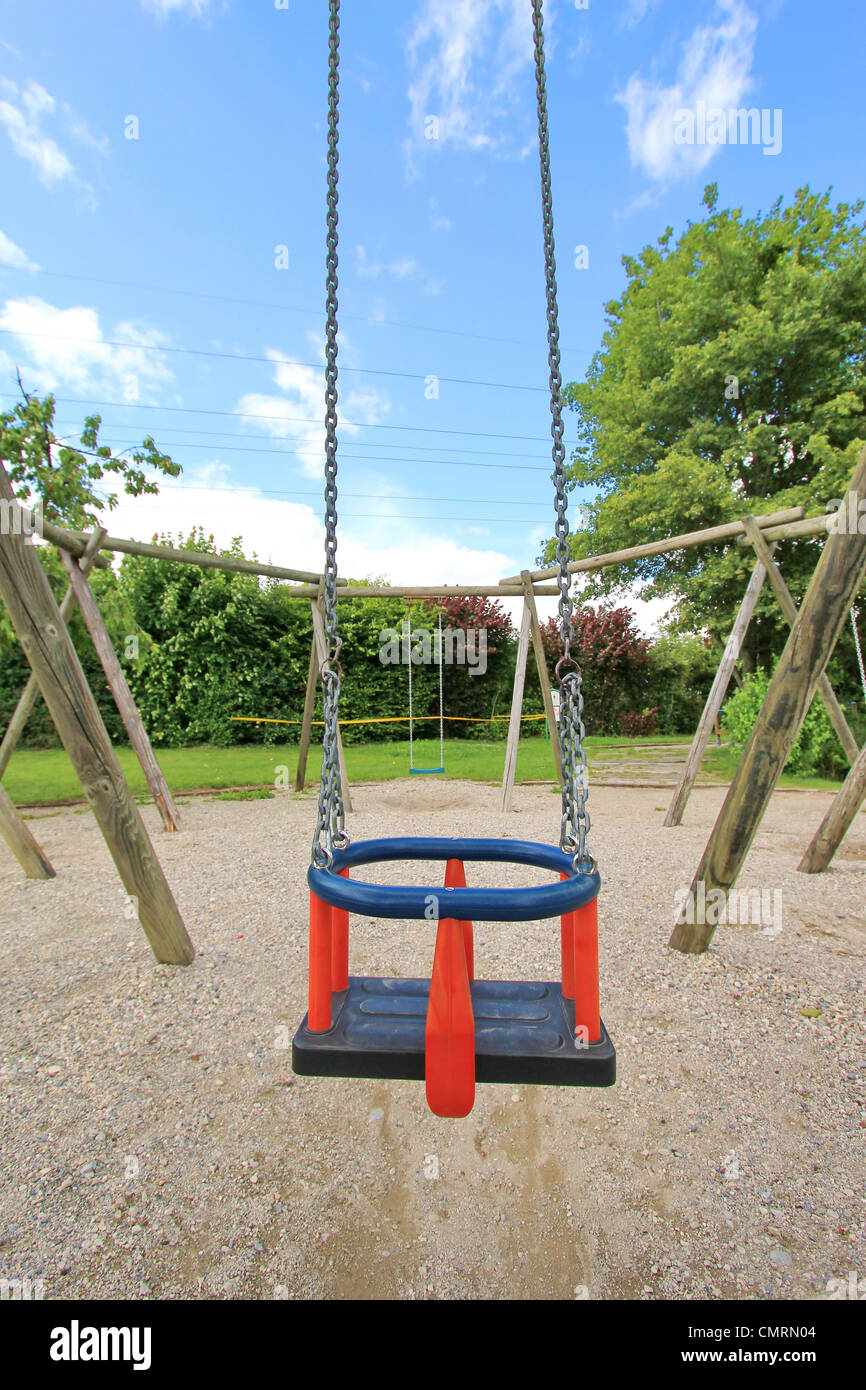 Parque infantil con columpio para bebés y deslice cerca de casas Fotografía  de stock - Alamy