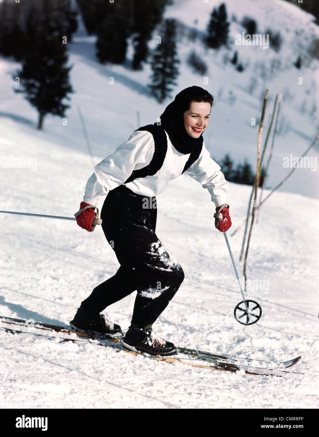 1940 1950 mujer sonriente esquí vestido de azul y blanco vestido rojo con  Guantes de ski Fotografía de stock - Alamy