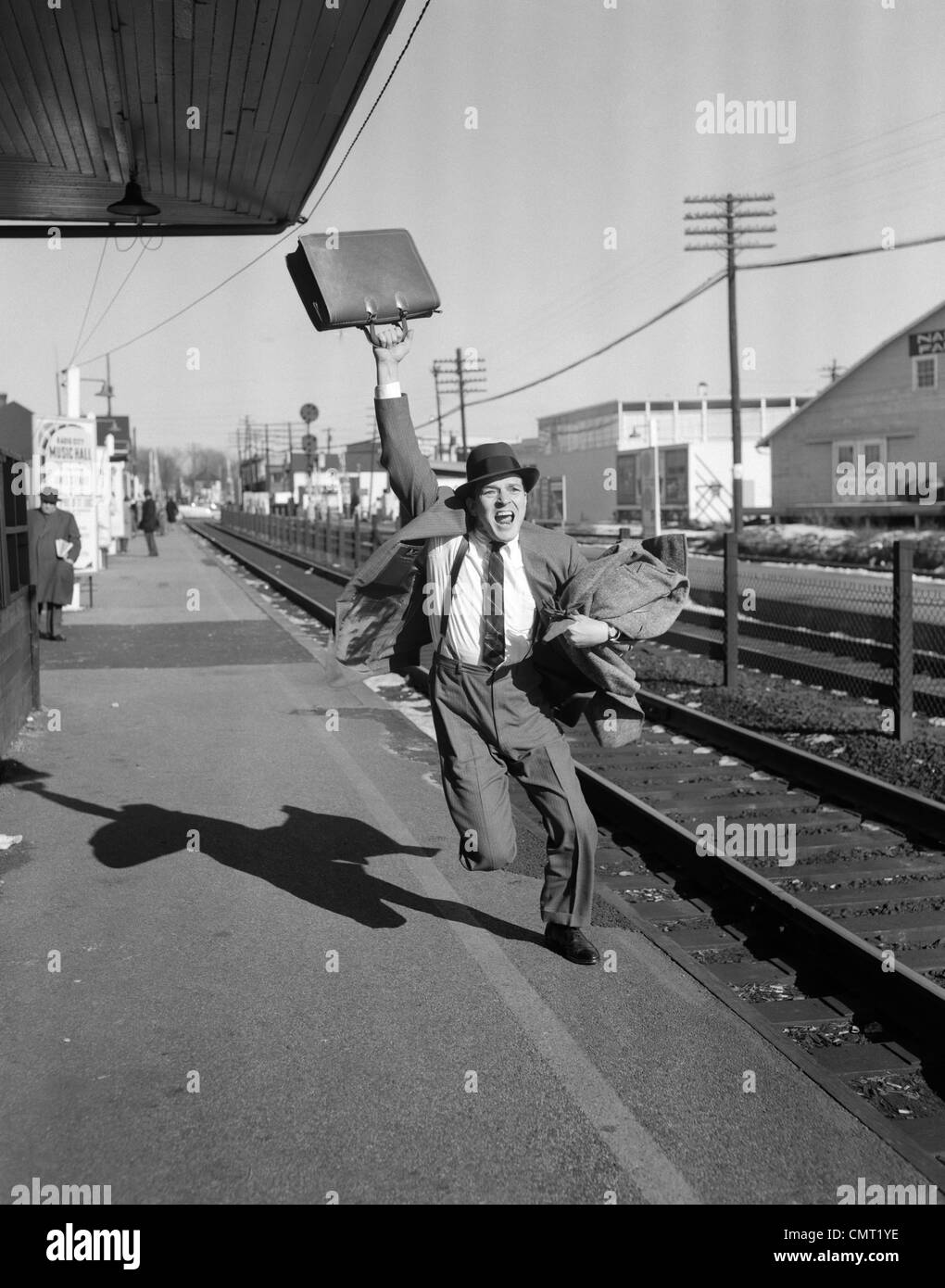 1950 empresario con maletín en el aire después de salir corriendo el tren Foto de stock