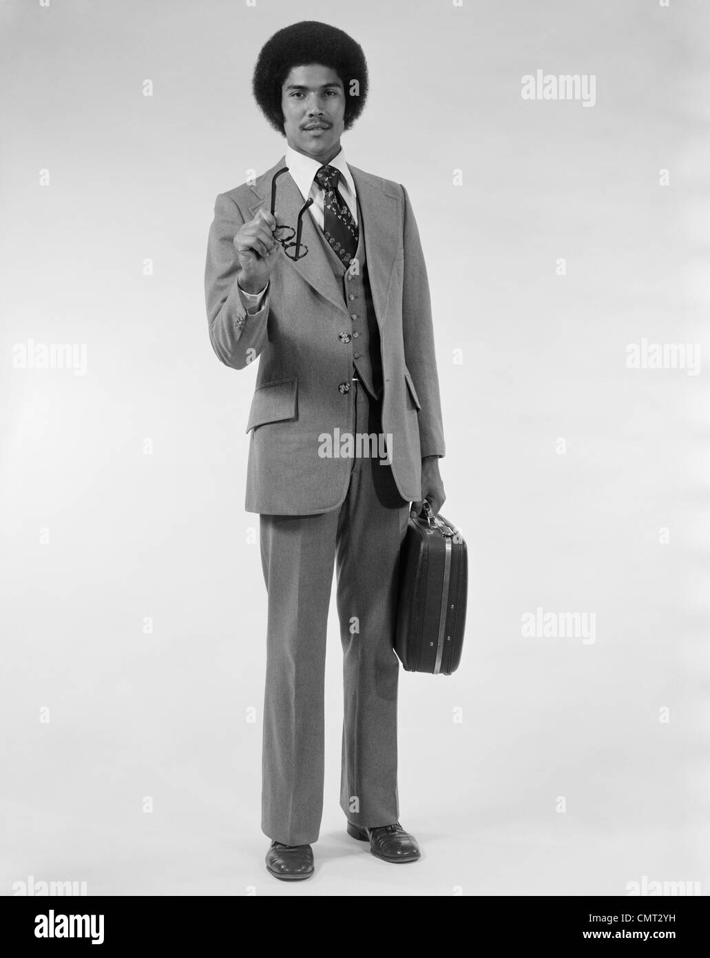 1970 Hombre negocios americano africano TRAJE DE TRES PIEZAS MALETÍN apuntando con anteojos Fotografía de stock - Alamy