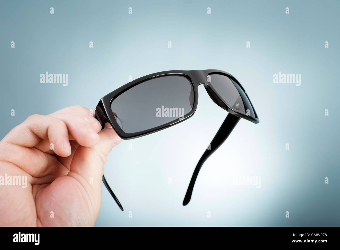 Hombre sujetando un par de gafas de sol de moda de alta calidad en su mano  Fotografía de stock - Alamy