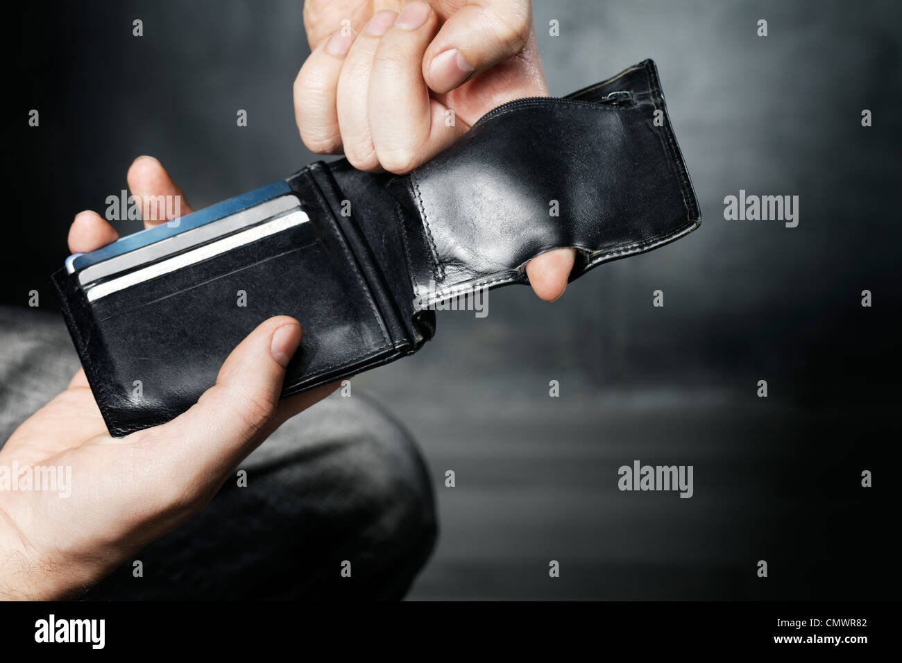 El hombre muestra el agujero en el bolsillo de su moneda vieja billetera. Foto de stock