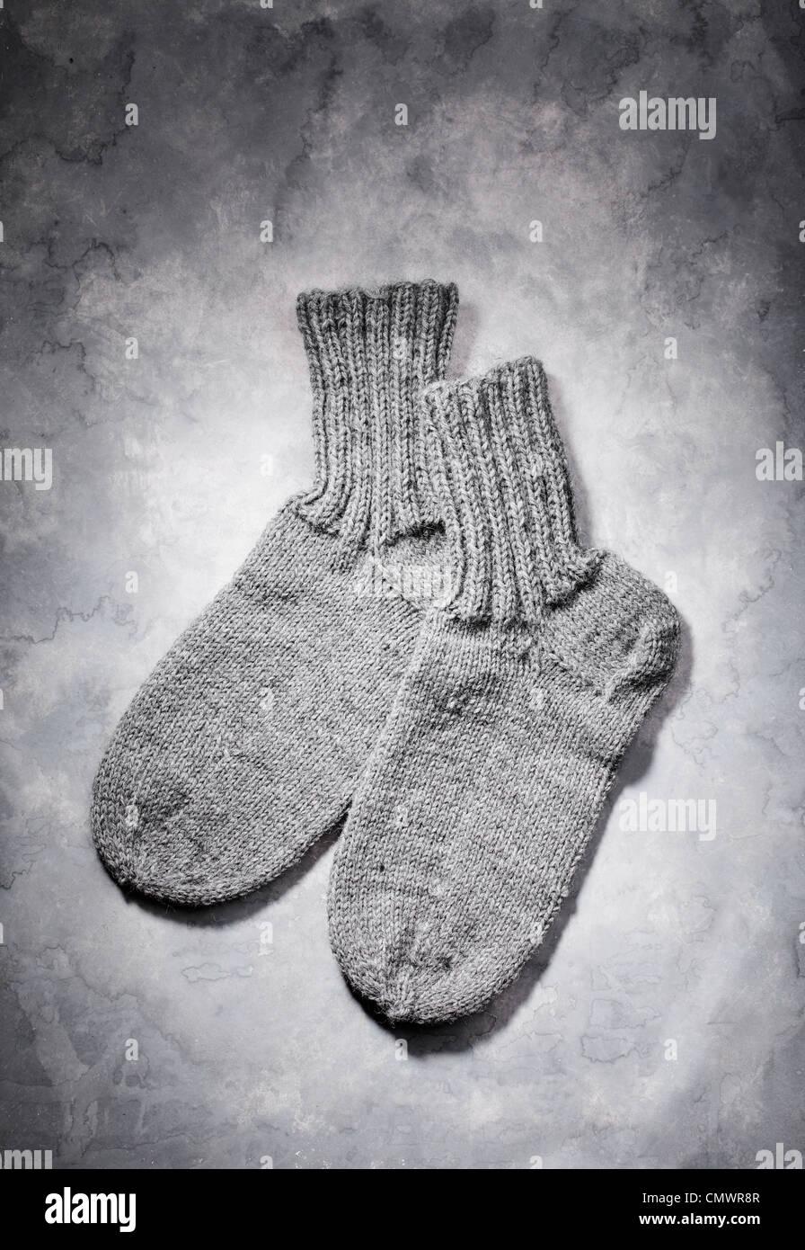 Tejidos a Mano calcetines de lana gris sobre fondo gris Foto de stock