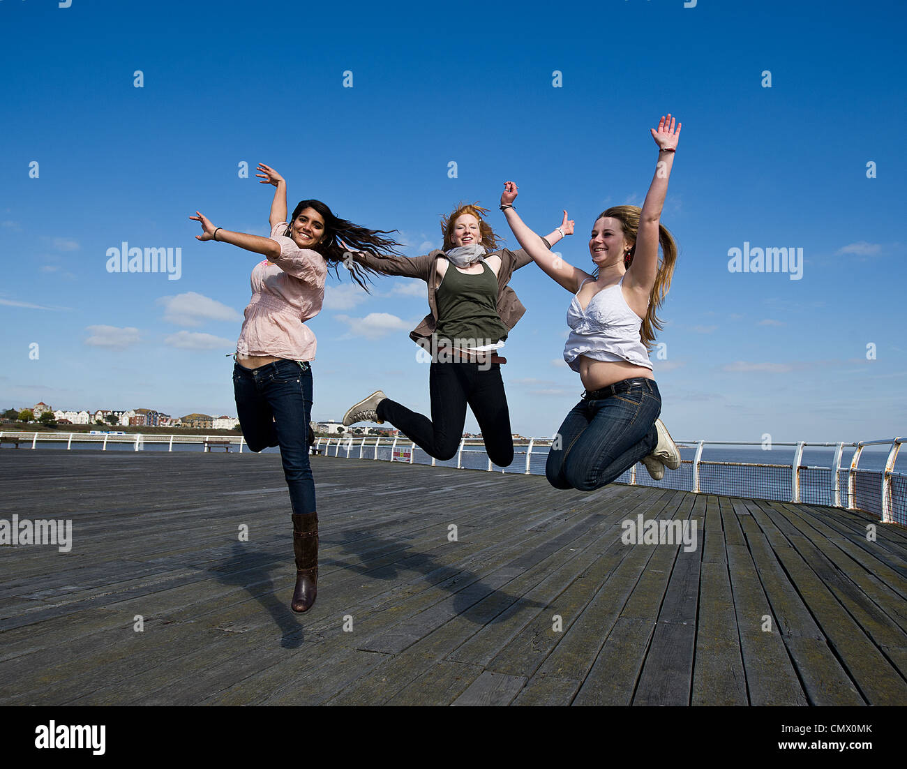 Tres niñas saltar en el aire Foto de stock