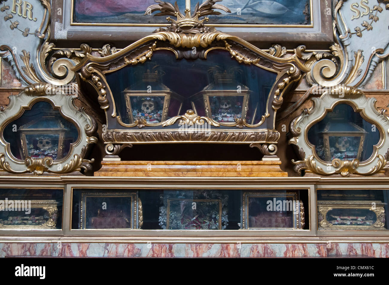 / Santo sacerdote queda en casos de vidrio ornamental en una iglesia católica en Bergamo Foto de stock