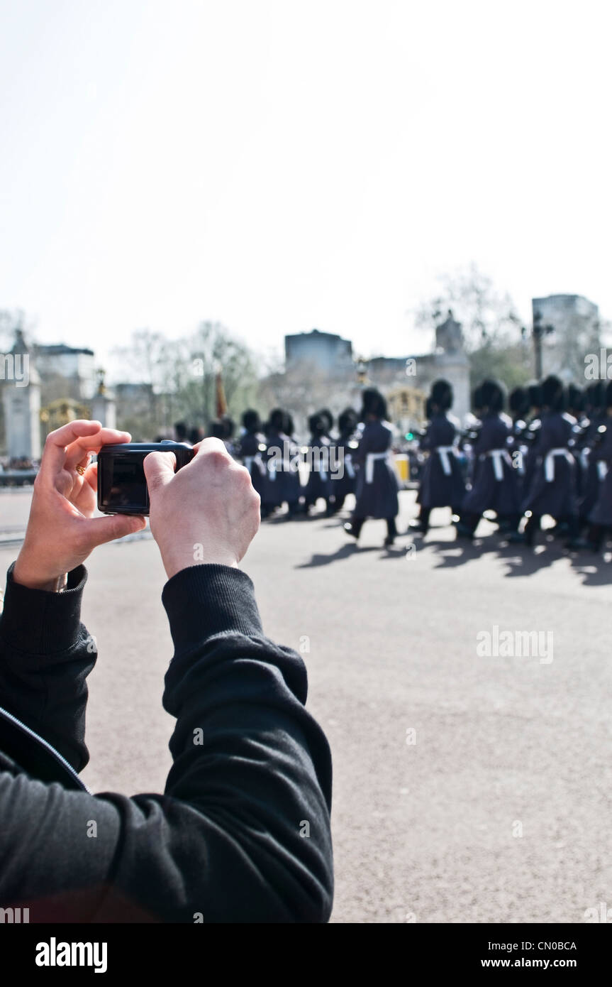 Un turista tomar fotografías en un desfile, guardias de Buckingham Palace Foto de stock