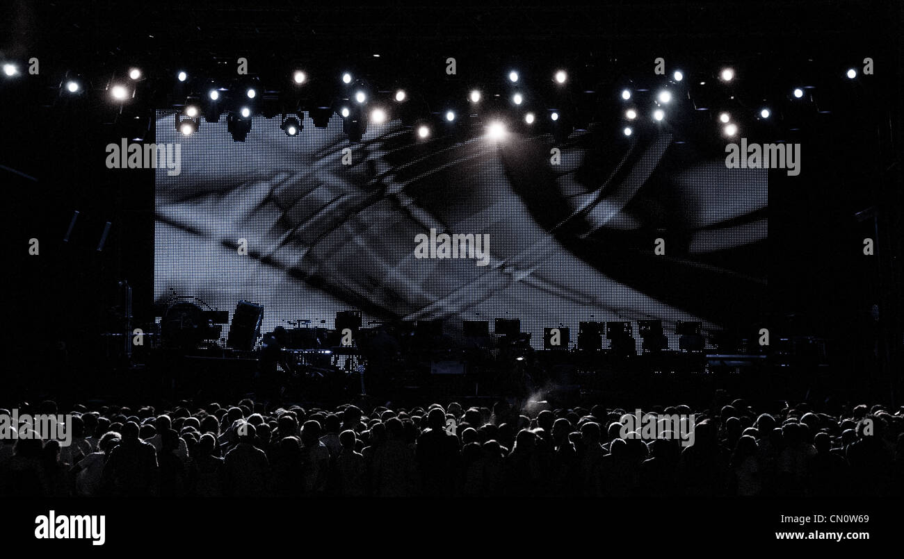 Una oscura turba de personas esperando para un concierto para comenzar