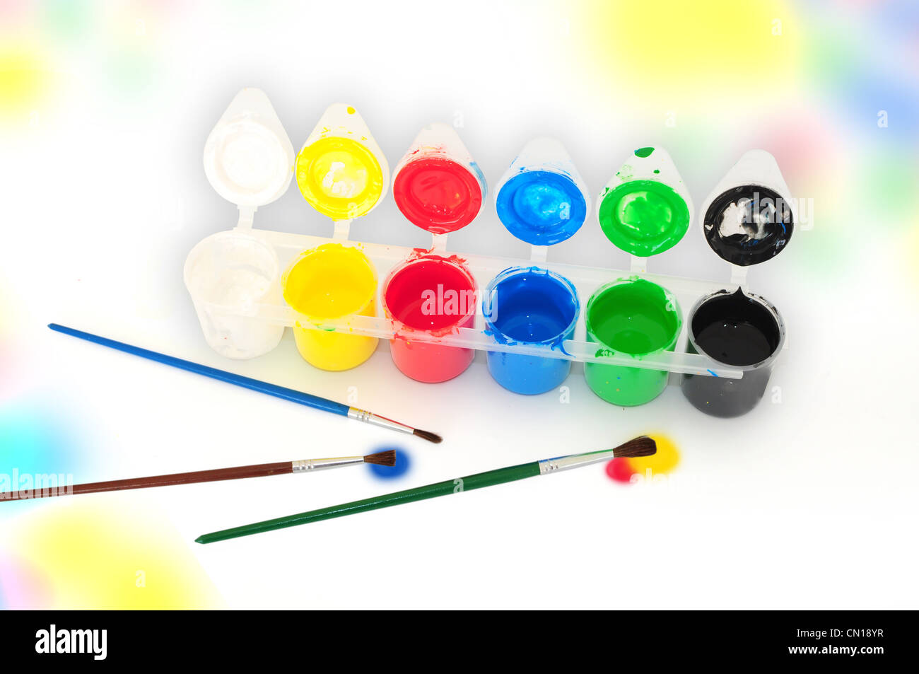 Conjunto de témperas y pinceles sobre fondo de colores Fotografía de