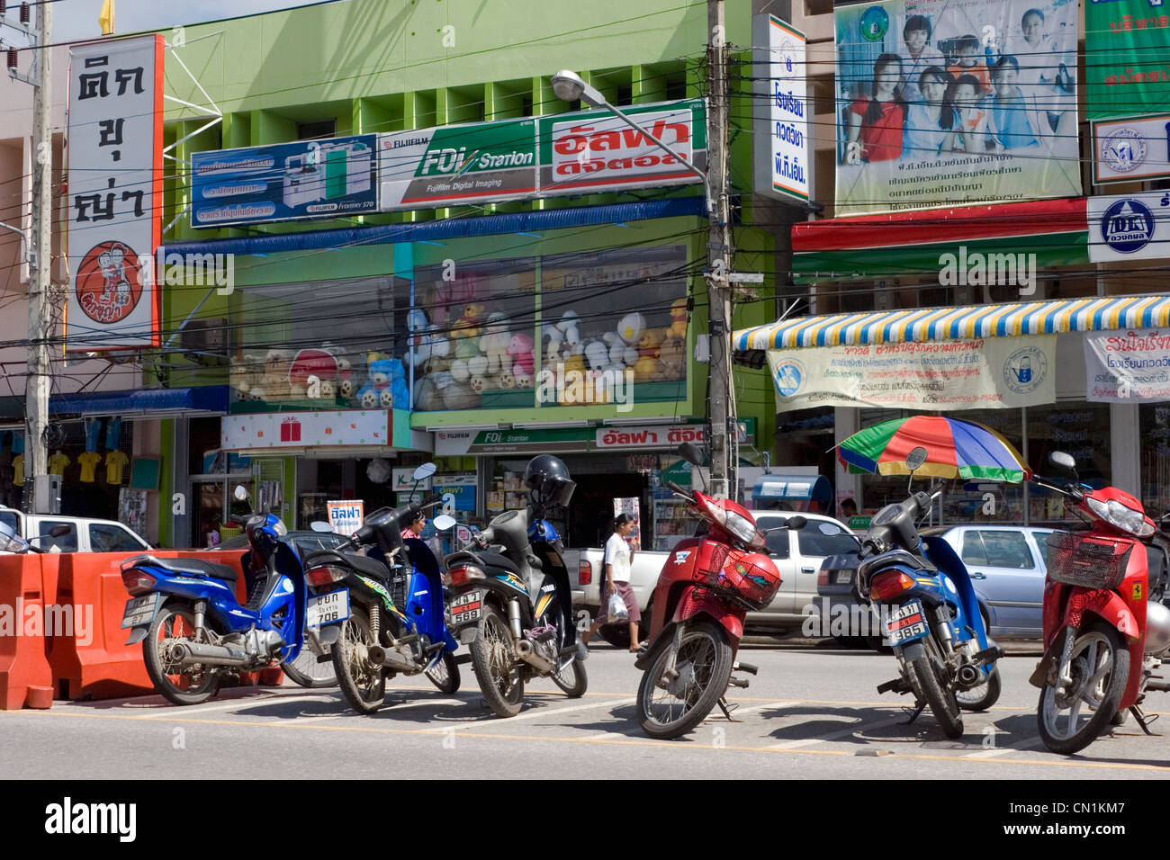 Las motocicletas están aparcados en frente de las tiendas en una calle de la ciudad de Chiang Rai, Tailandia. Foto de stock