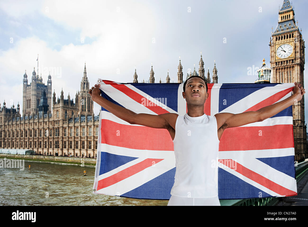Competidor olímpico con Union Jack en frente de las Casas del Parlamento, Londres, Inglaterra Foto de stock