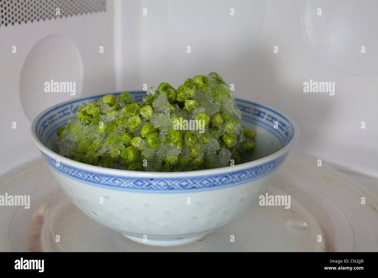 Los guisantes congelados descongelación en microondas Fotografía de stock -  Alamy