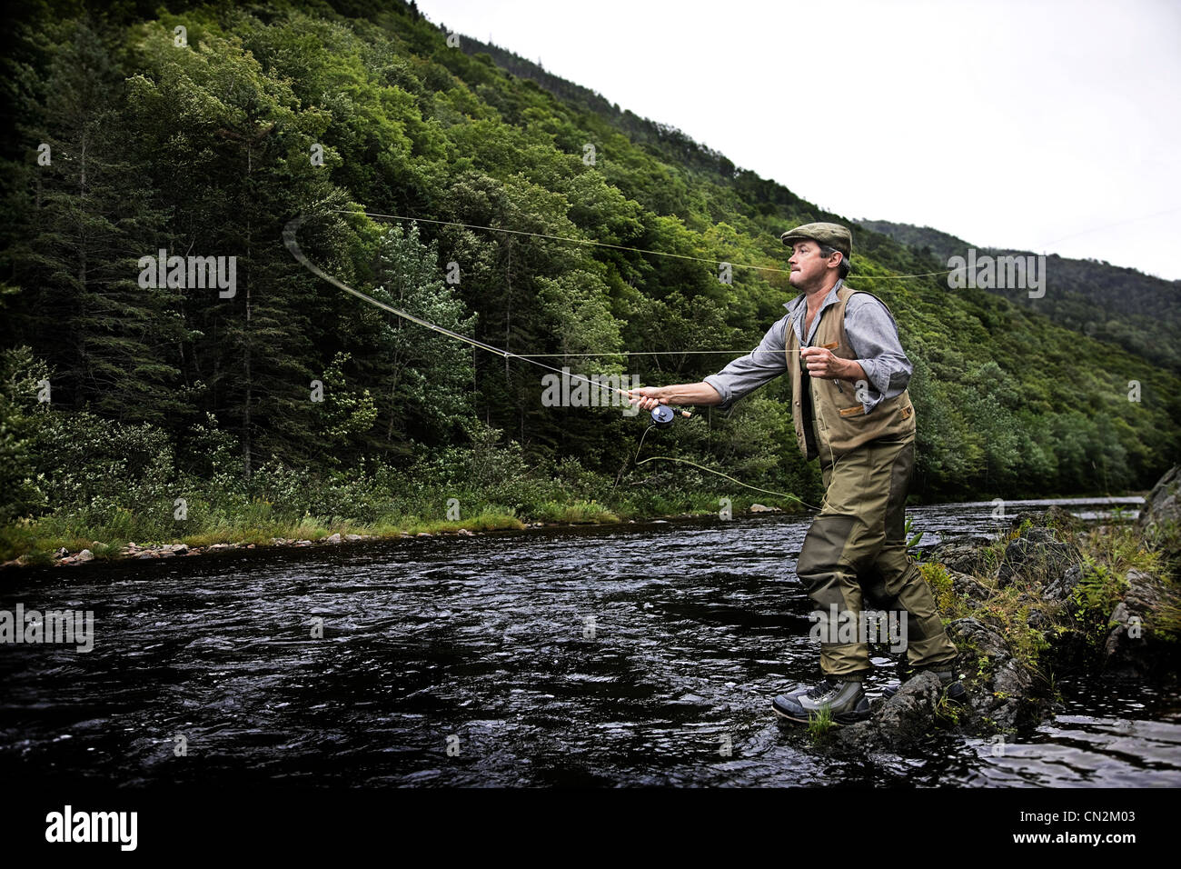 Pescador con mosca en Río Margaree, la isla de Cape Breton, Nova Scotia Foto de stock