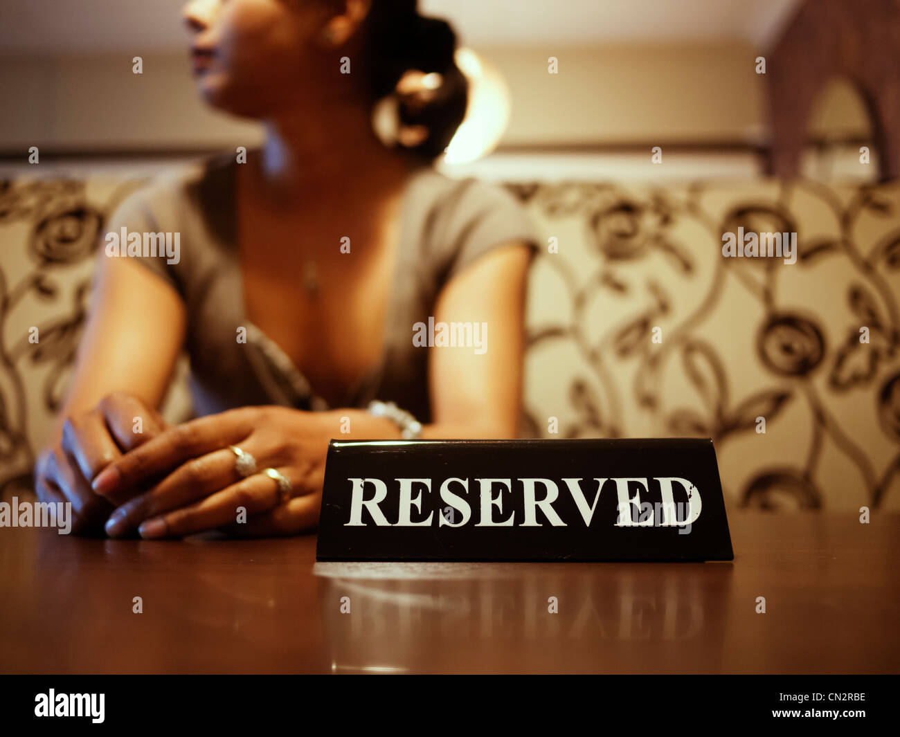 Punjabi mujer espera en mesa reservada Foto de stock