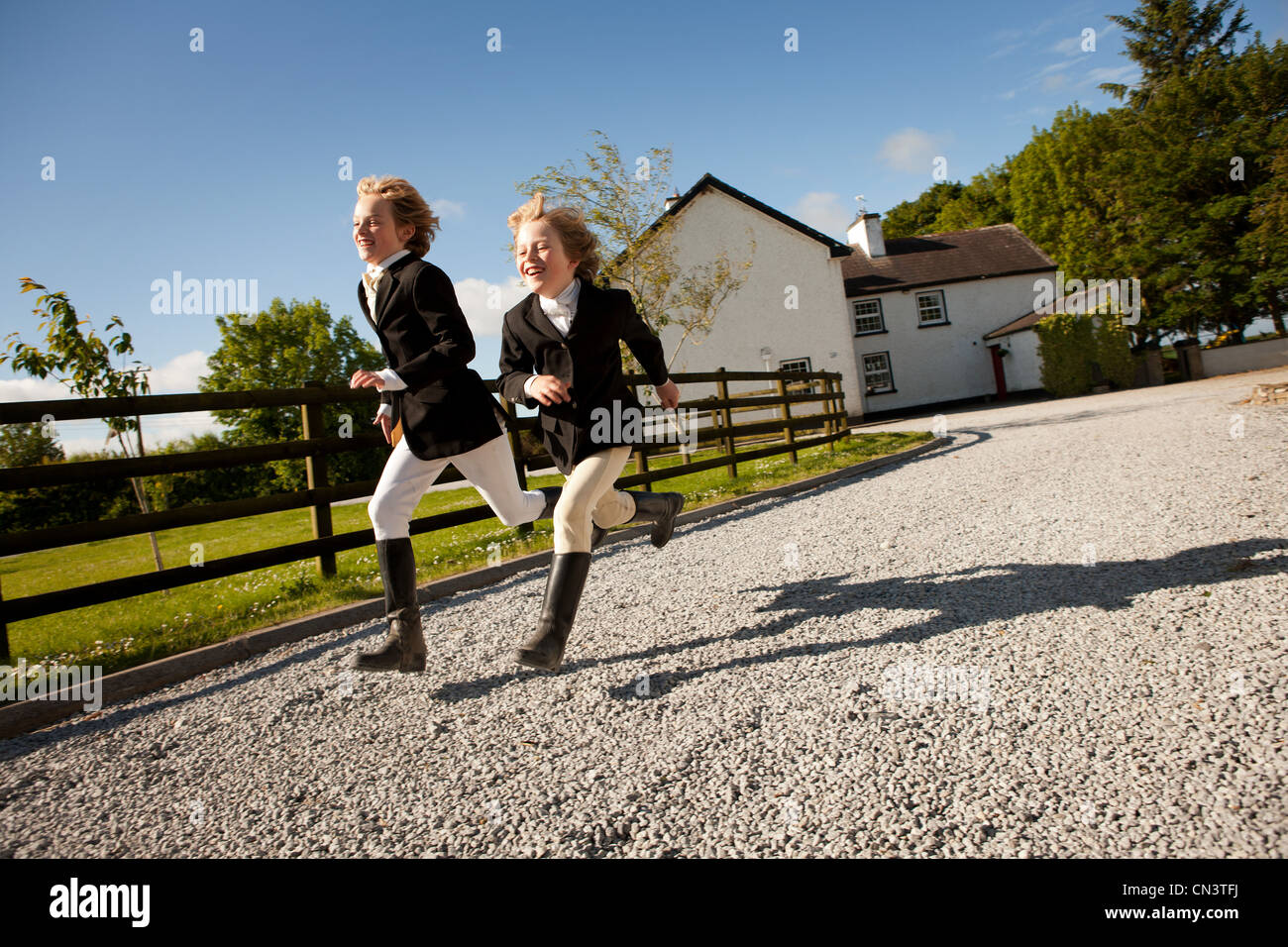 Los niños corriendo por el camino de gravilla de rancho Foto de stock