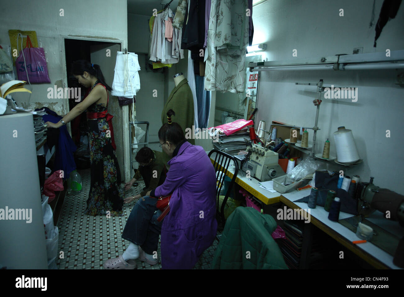 Señora china tener un vestido apenas en la tienda de ropa local. Foto de stock