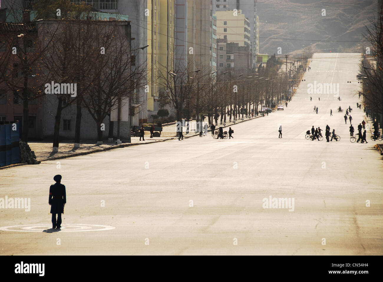 Corea del Norte, Kaesong, oficial de policía haciendo el tráfico en una calle sin coches. Foto de stock