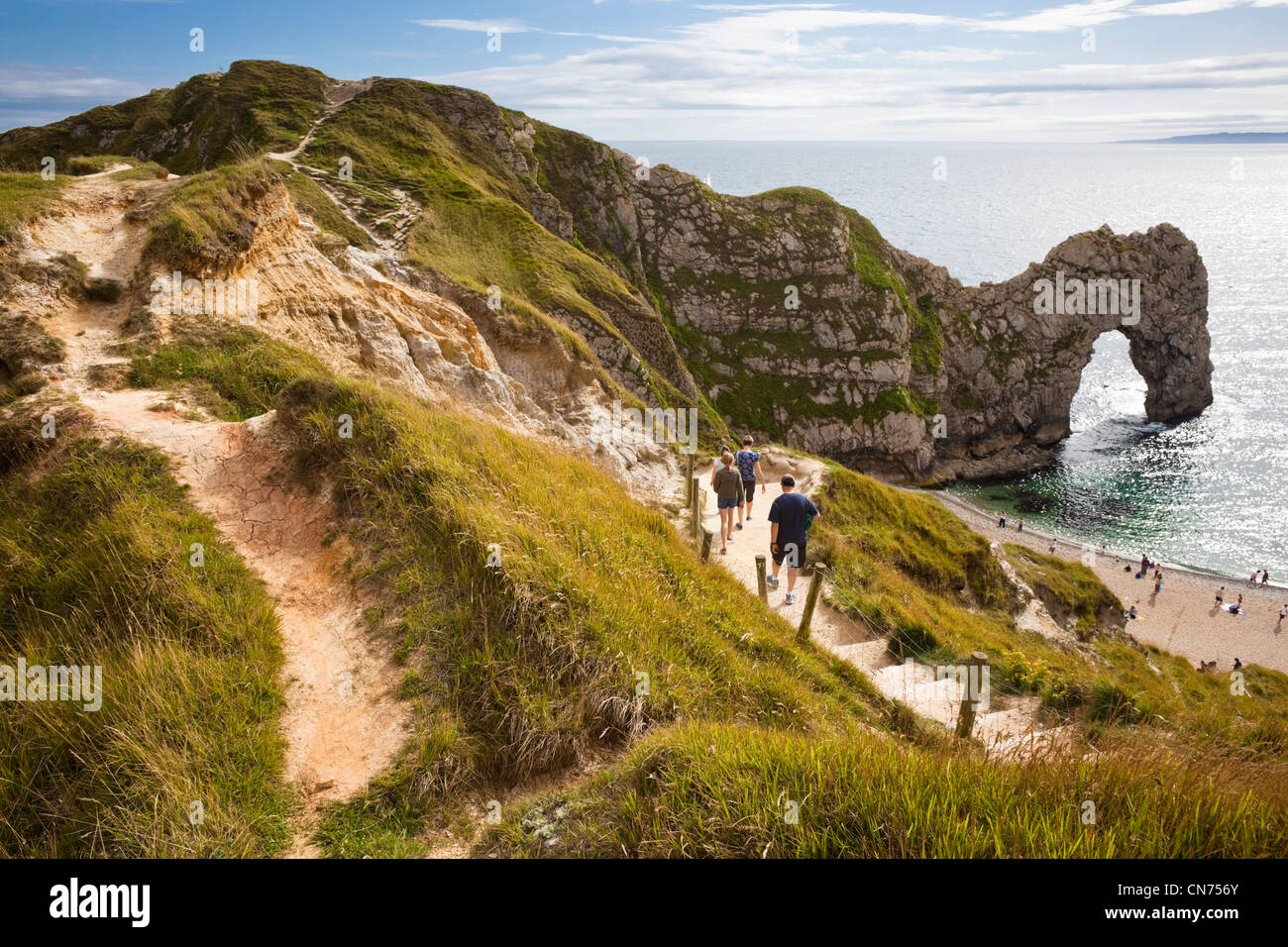 Vista de la puerta de Durdle sobre la Costa Jurásica, costa de Dorset, Inglaterra, Reino Unido - con los turistas que caminan hacia la playa en verano Foto de stock