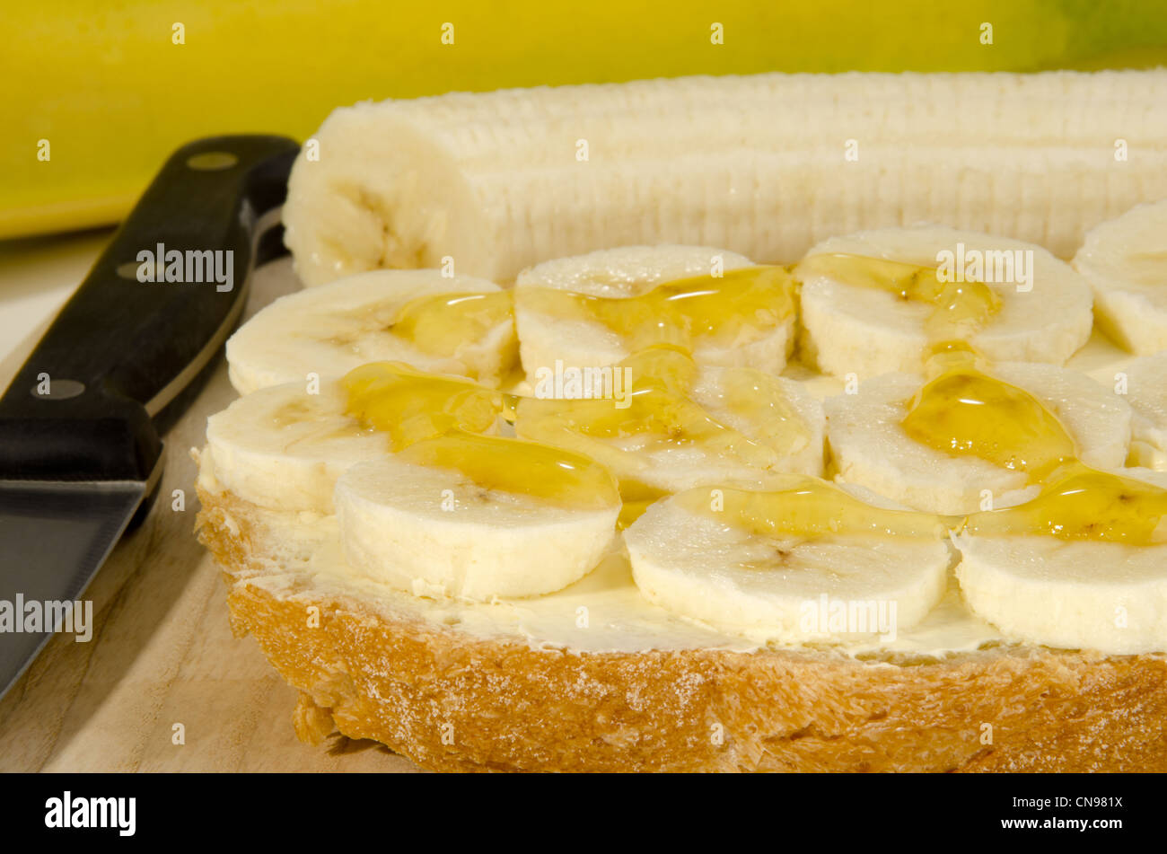 Rebanada de pan con rodajas de plátano y miel Foto de stock