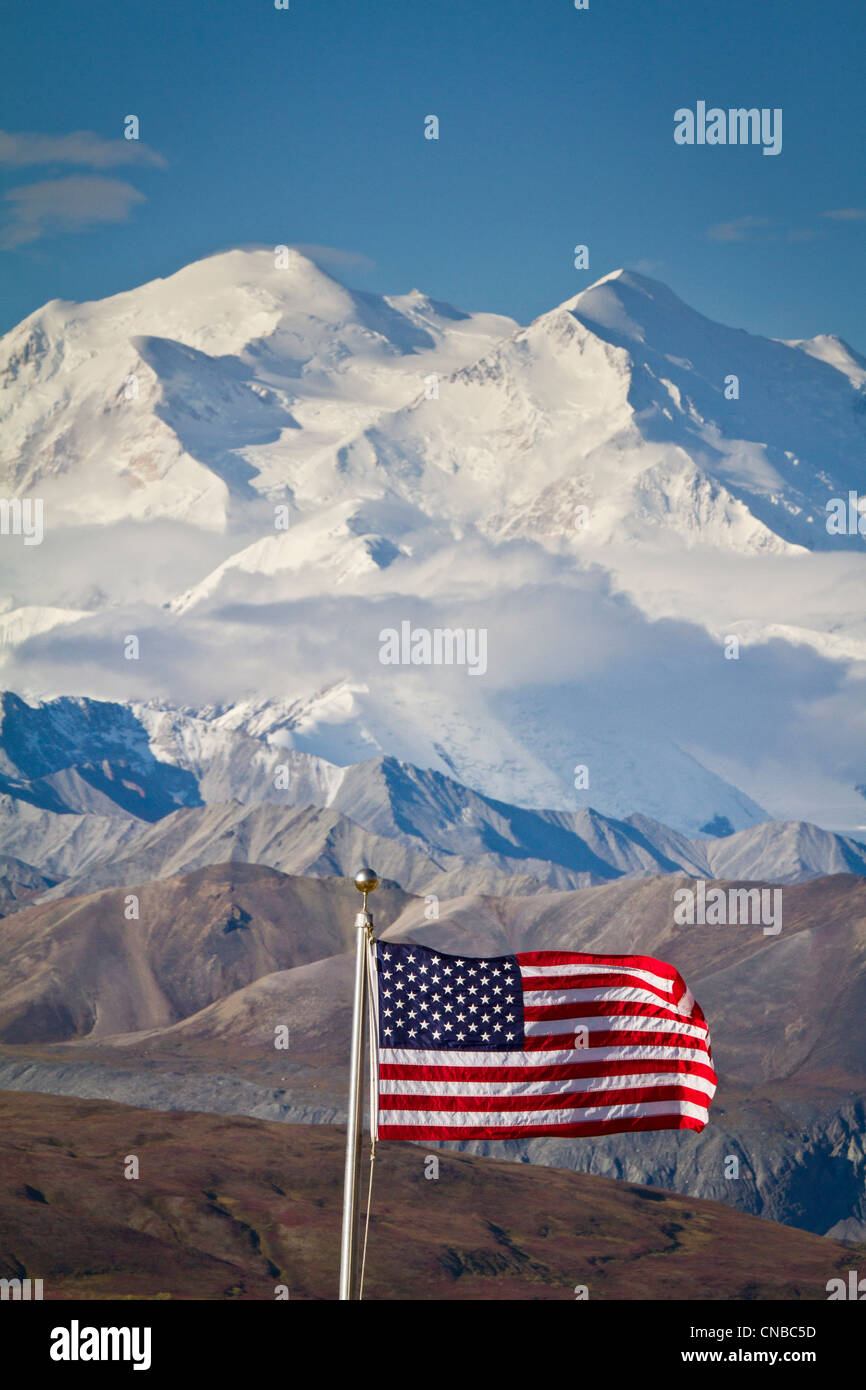 Una bandera americana vuela en el viento a Eielson Visitor Center con Mt. Mckinley en el fondo, el Parque Nacional Denali, Alaska Foto de stock