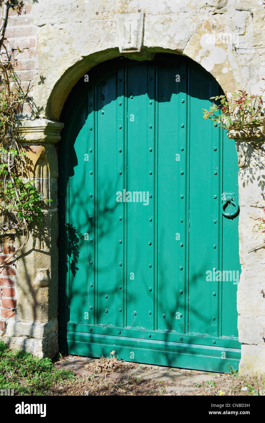Puerta de madera pintado de verde en la pared de ladrillo y piedra en un  jardín inglés Fotografía de stock - Alamy