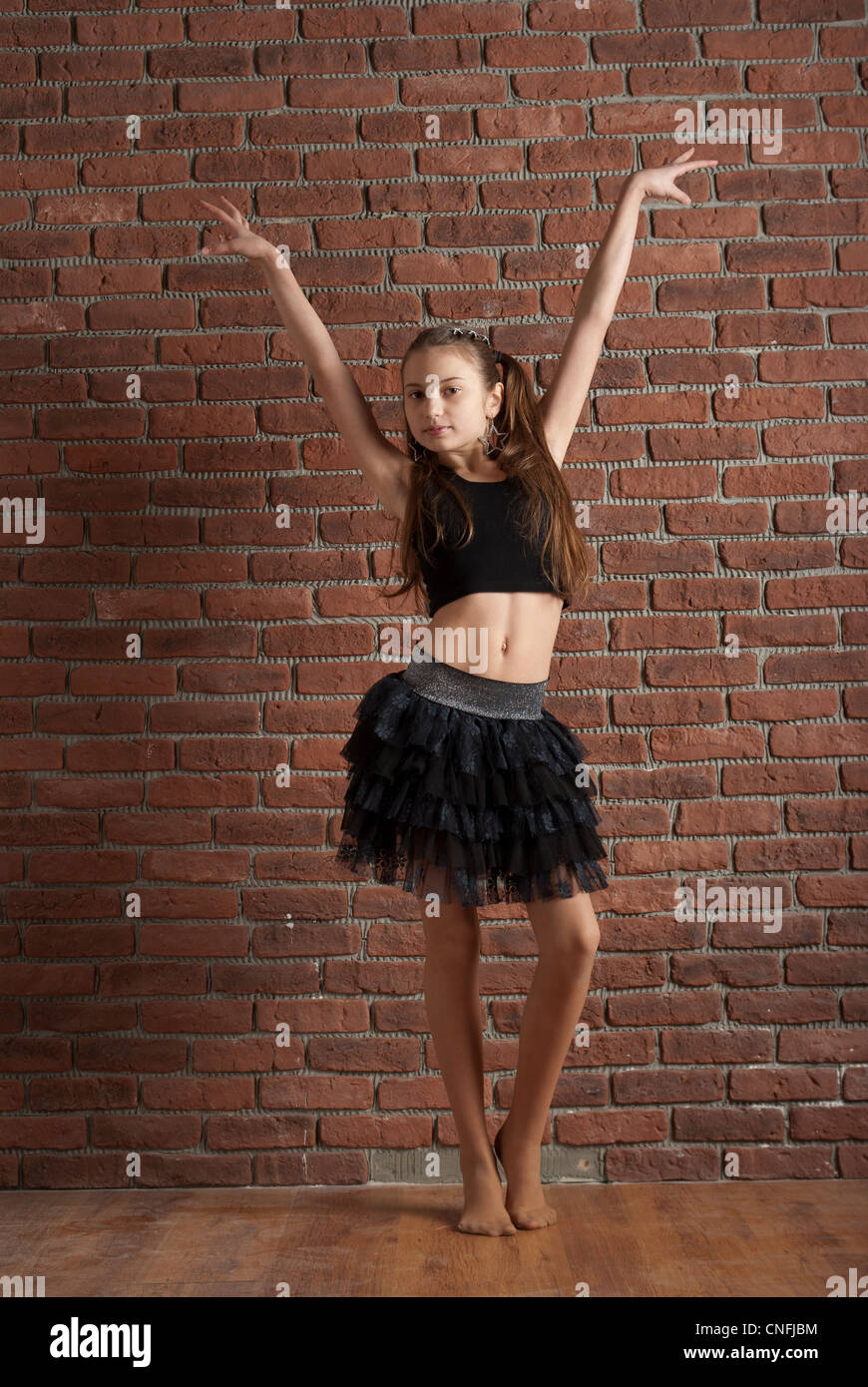 Chica en falda negra bailando cerca de la pared de ladrillo Fotografía de  stock - Alamy