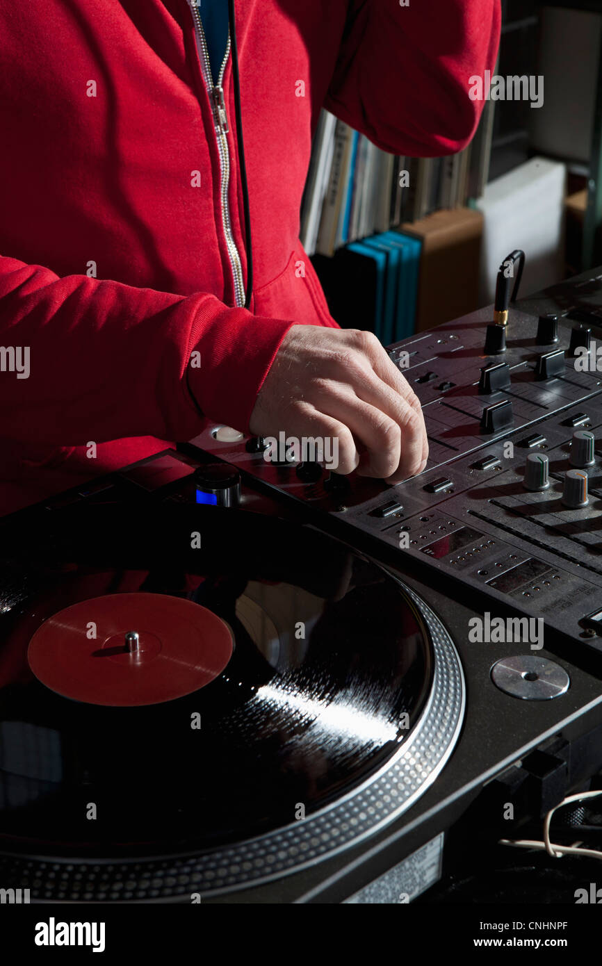Una perilla de ajuste de DJ en un mezclador de sonido, detalle de manos Foto de stock