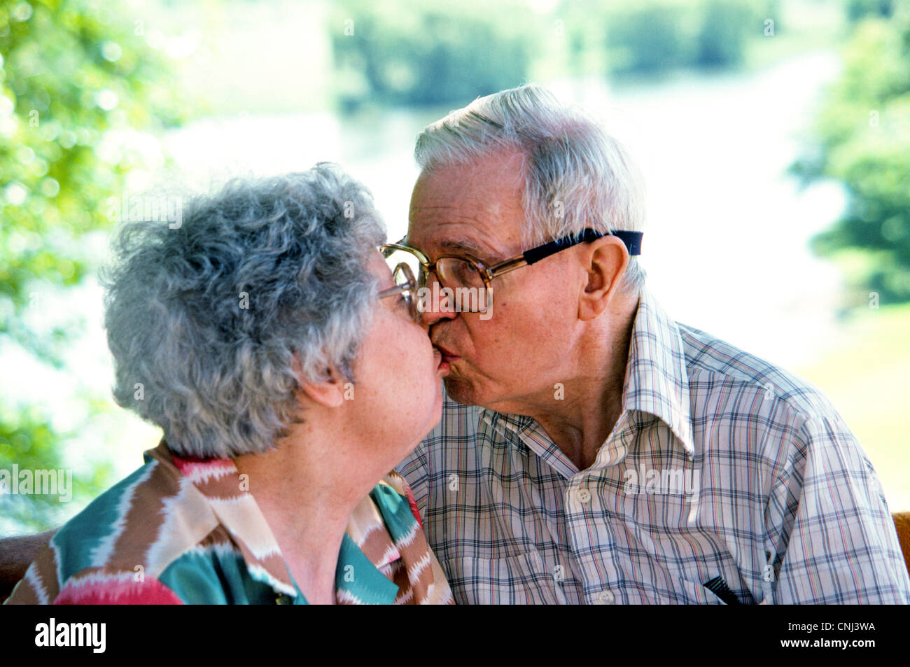 Una anciana pareja americana Pucker Up para un beso en la celebración de su 50 aniversario de boda en un día soleado de verano. Foto de stock