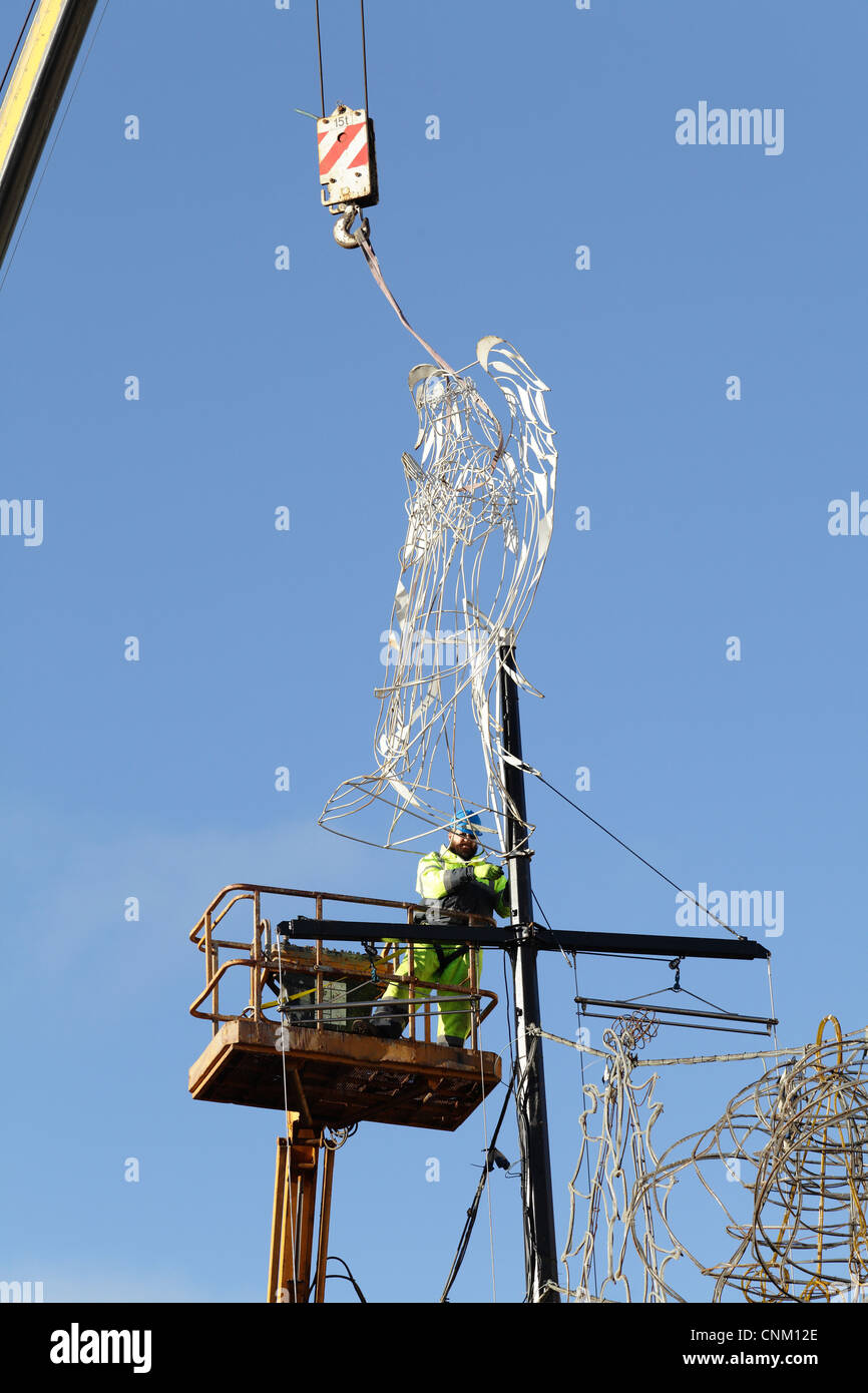 Obrero con una grúa y una eslinga para retirar luces y decoraciones de Navidad, REINO UNIDO Foto de stock