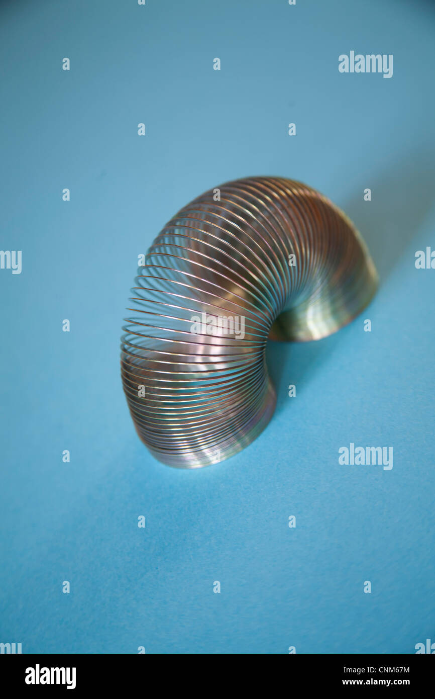 Slinky o perezoso juguete de resorte hechas de un resorte helicoidal que se extiende y puede rebotar hacia arriba y hacia abajo Foto de stock