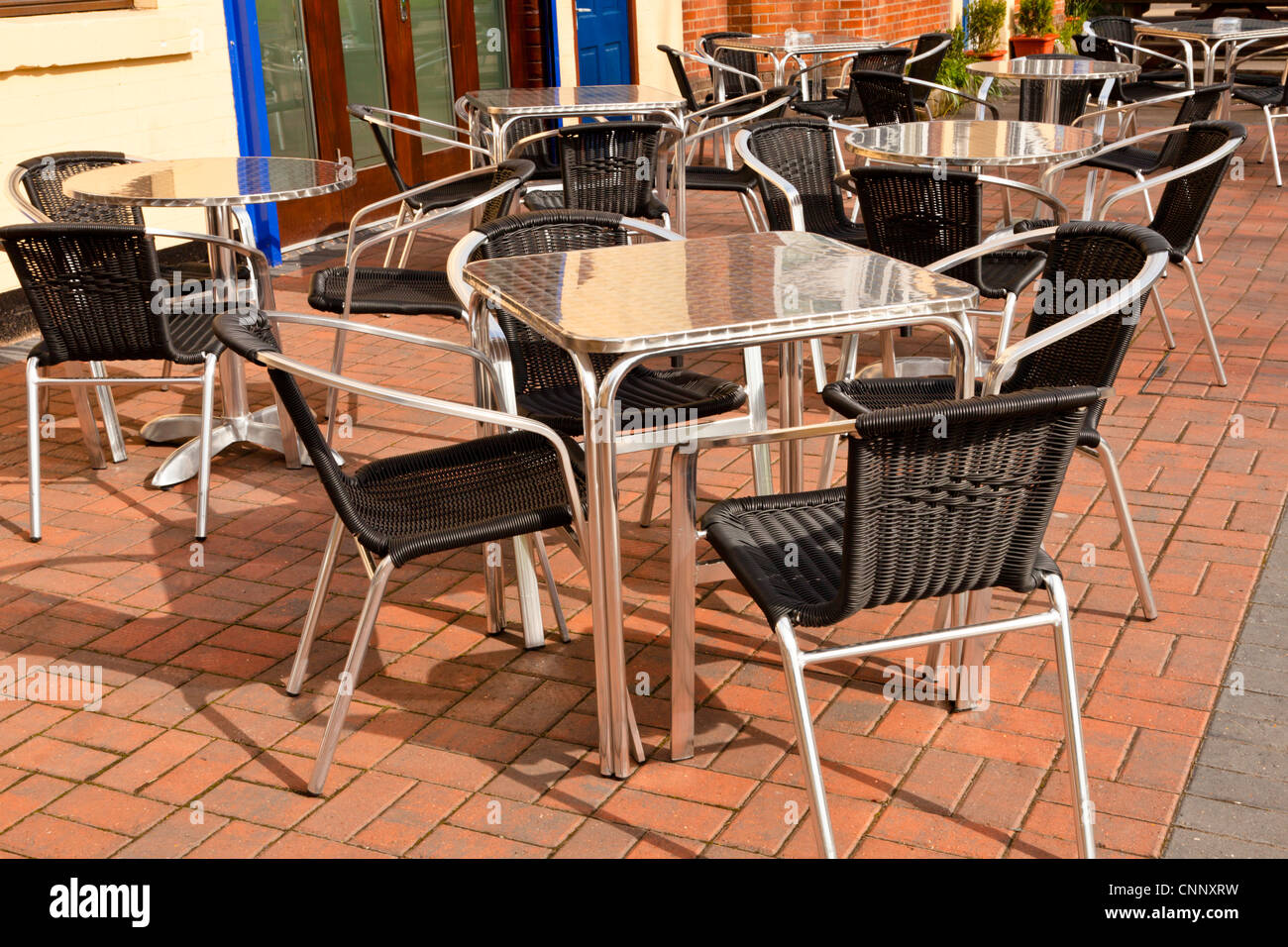 Mesas y sillas de aluminio en una zona de estar exterior, Reino Unido. Foto de stock