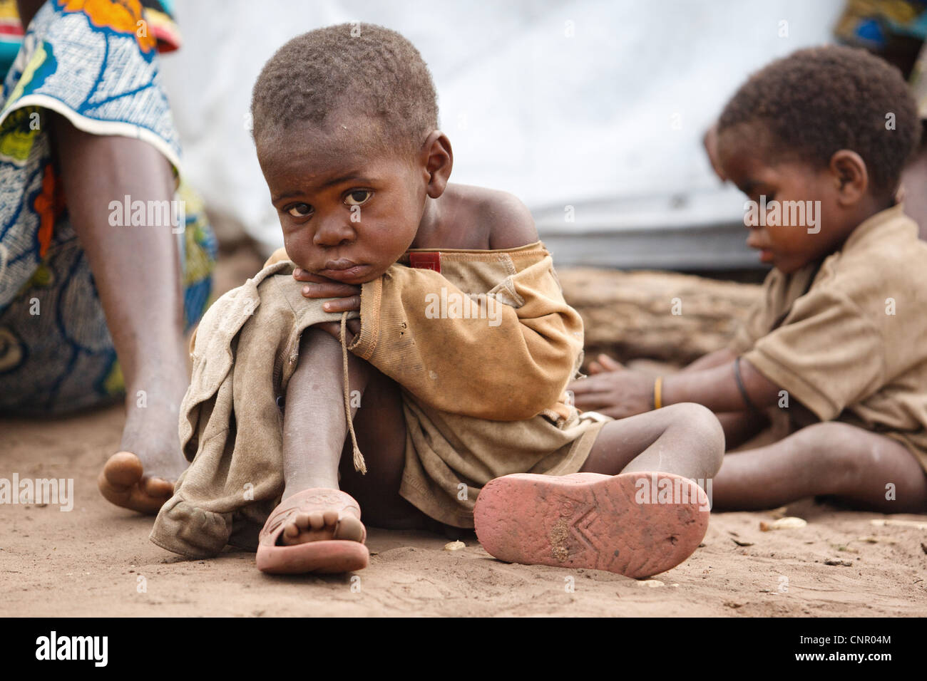 Un niño se sienta en el suelo en los asentamientos de desplazados internos Miketo, provincia de Katanga, en la República Democrática del Congo Foto de stock