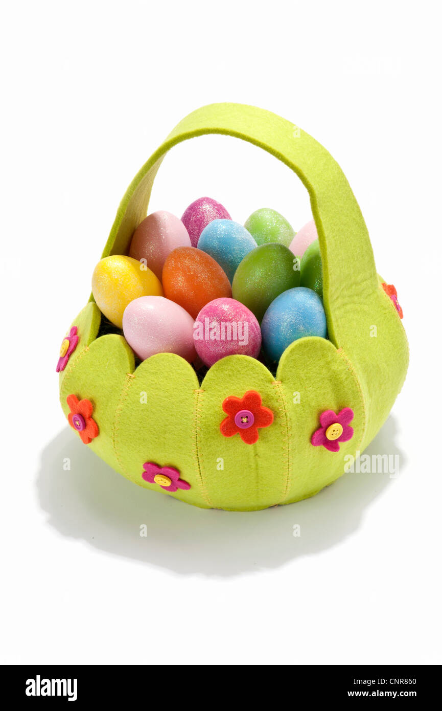 Una canasta llena de huevos coloreados Foto de stock