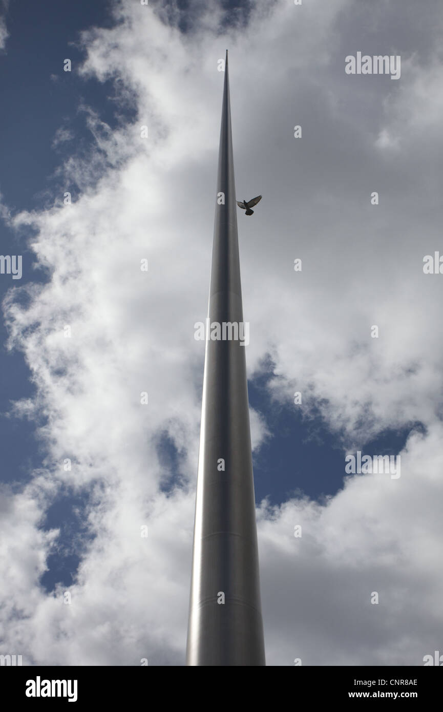 Un pájaro volando cerca del Monumento de la luz o Spire de Dublín, que se encuentra en O'Connel Street, en el centro de la ciudad. Foto de stock