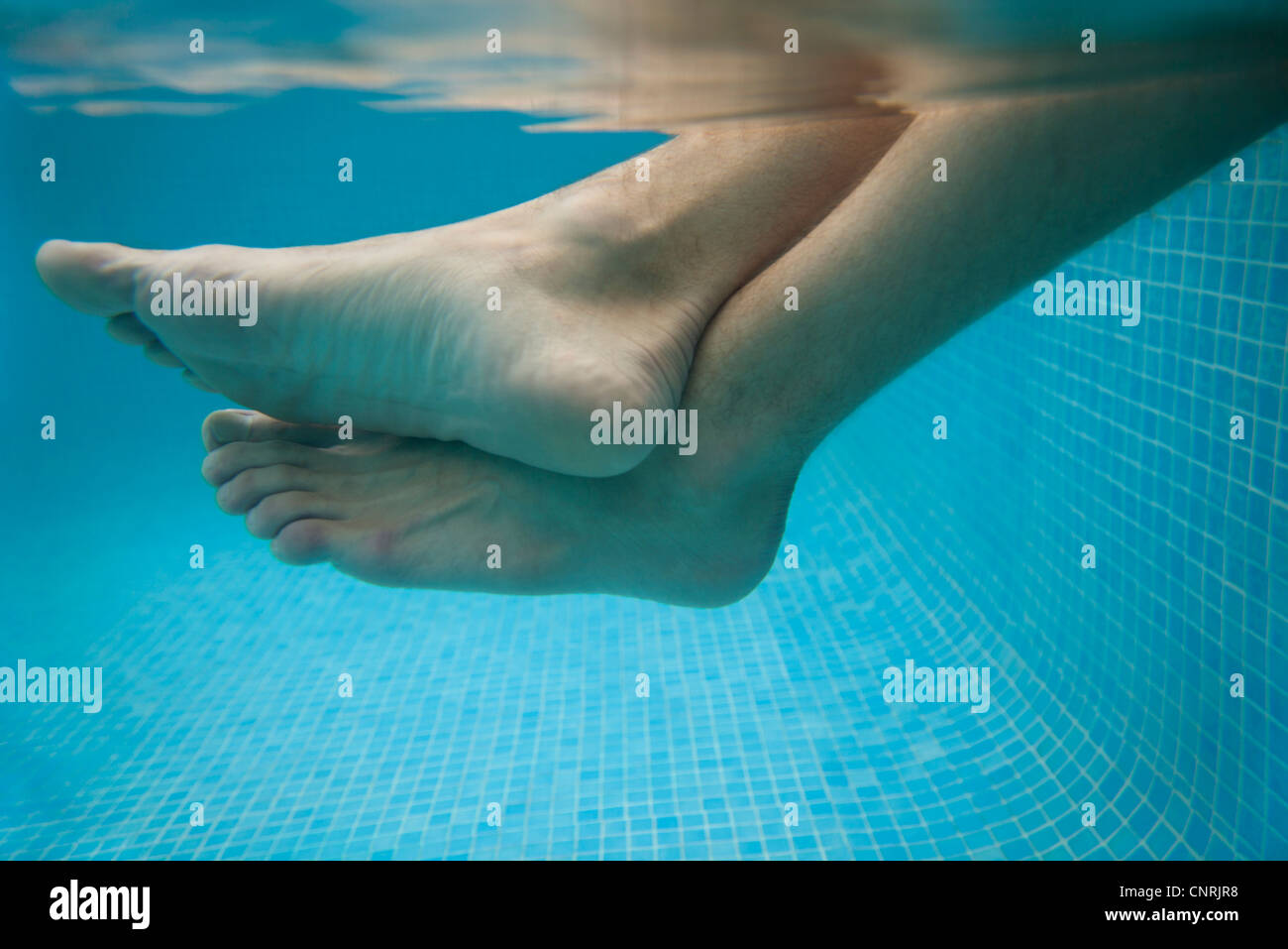 Las piernas del hombre en el agua, vista submarina Foto de stock