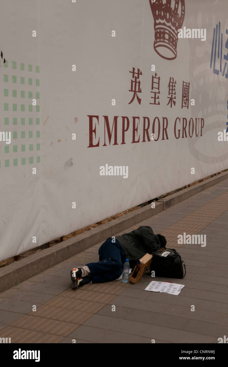 Vagabundos durmiendo en la acera en el centro de la ciudad de Pekín Foto de stock