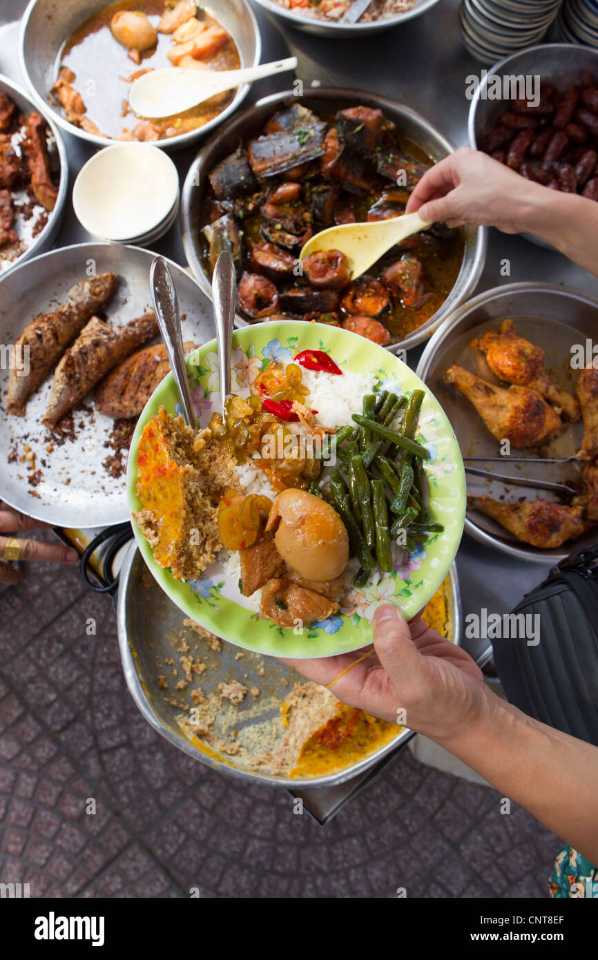 Persona que sirve comida de la calle preparado Foto de stock