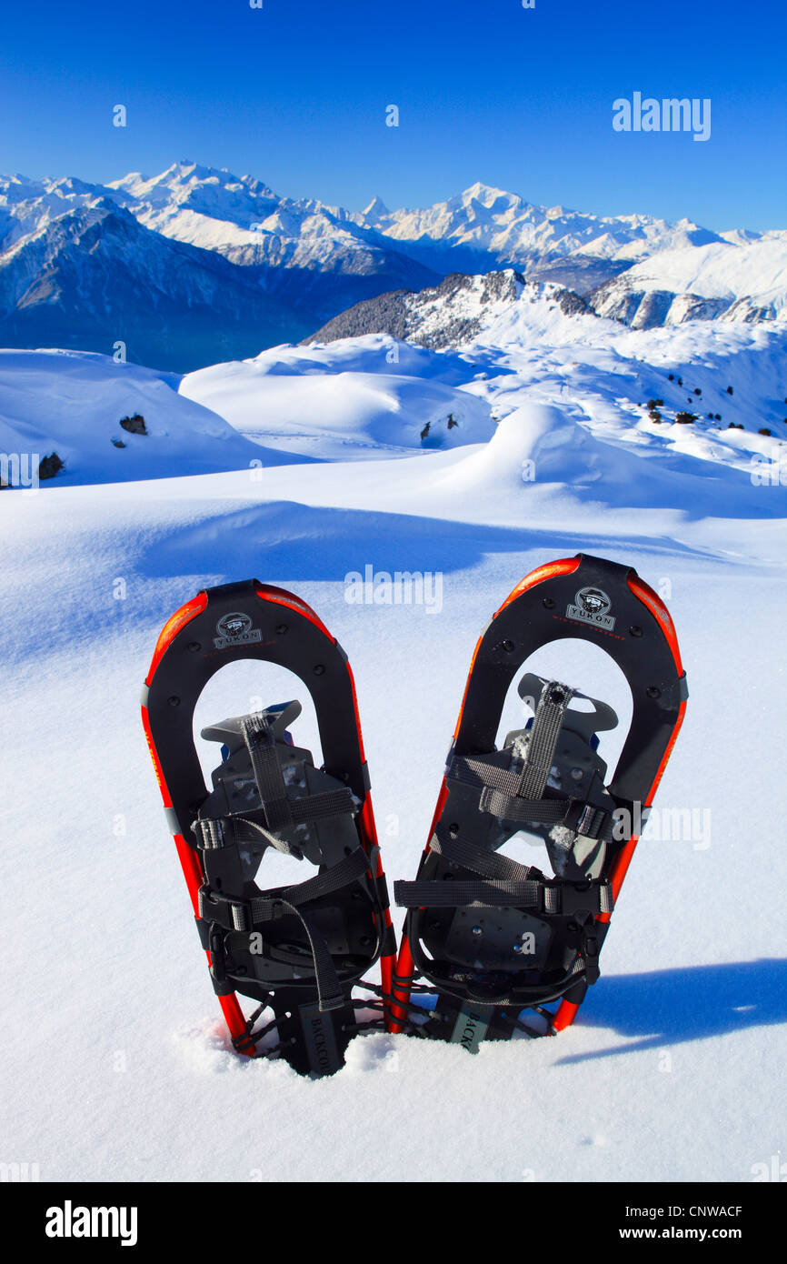Par de zapatos de nieve pegada en un campo de nieve intacta en los Alpes de  Valais en frente de Alphubel (4206 m), Dom (4545 m), Mischabelhoerner,  Matterhorn (4477 m) y el