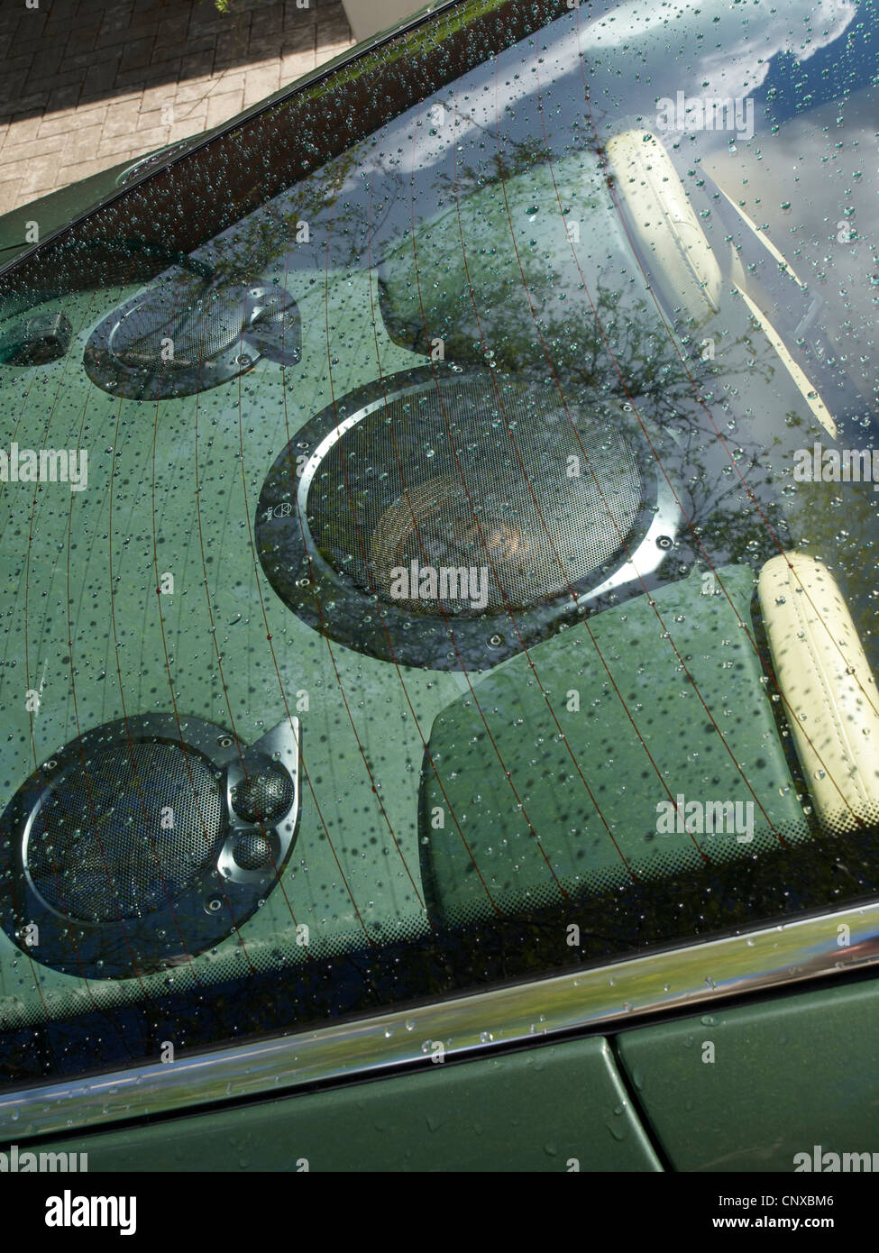 Los grandes altavoces detrás de la ventana trasera del coche deportivo de Aston Martin verde Foto de stock