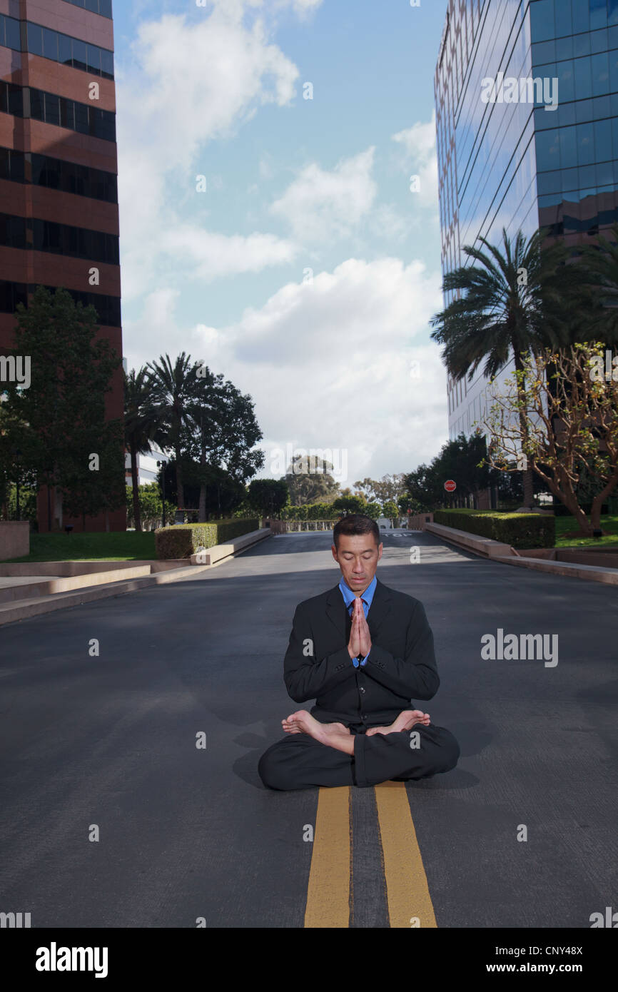 Empresario practicando yoga y meditación. Foto de stock