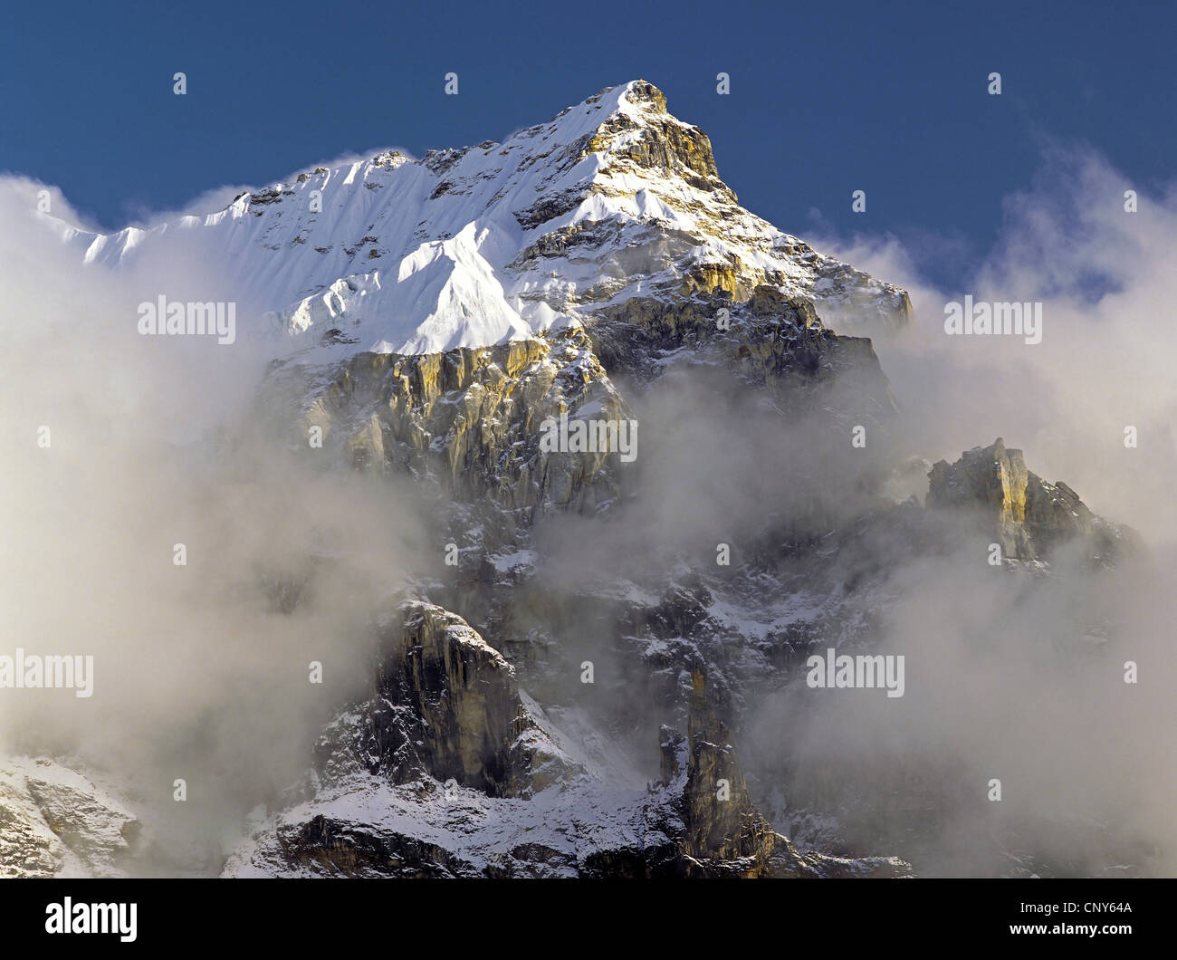 La niebla y las nubes se reúnen alrededor de los espectaculares riscos y la cumbre de un pico sin nombre en la región Kangchenjunga, Nepal, Kangchendzoenga, Jannu Foto de stock