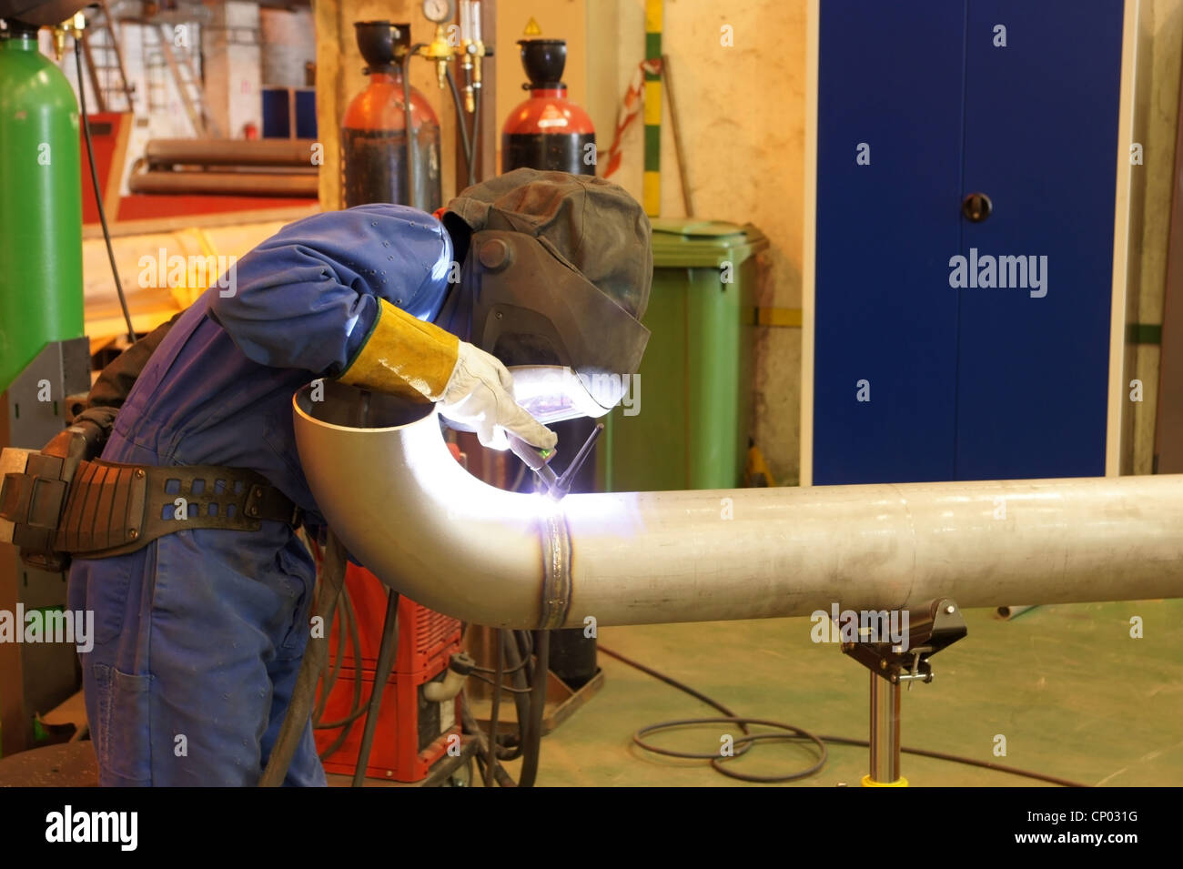 Trabajador de fábrica un tubo de metal de soldadura Foto de stock