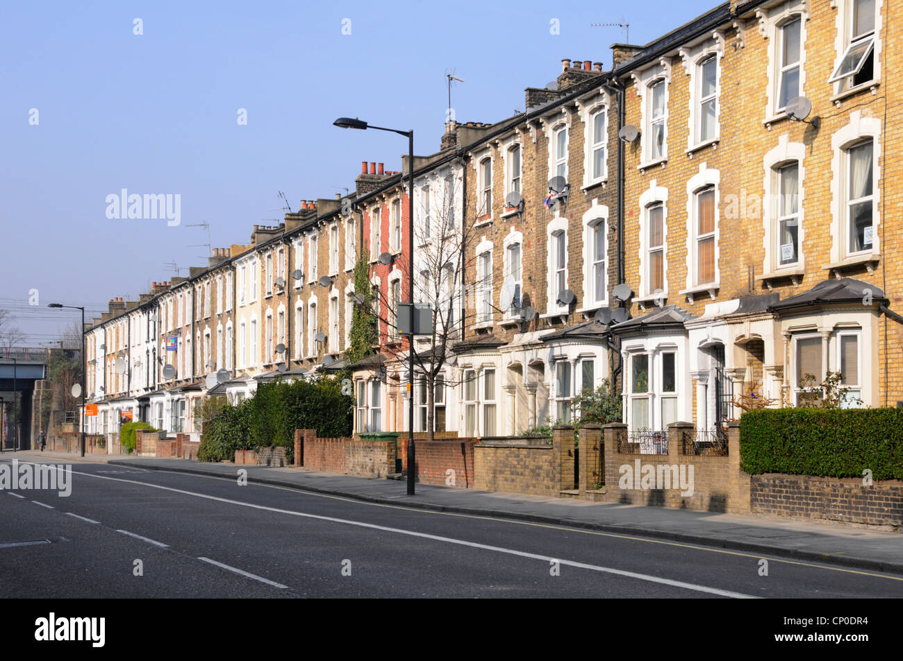 Hay una larga fila de apartamentos y apartamentos antiguos de tres pisos con terrazas, sin coches aparcados ni tráfico en Hackney London, cerca del centro de la ciudad y de la estación de tren, Inglaterra, Reino Unido Foto de stock