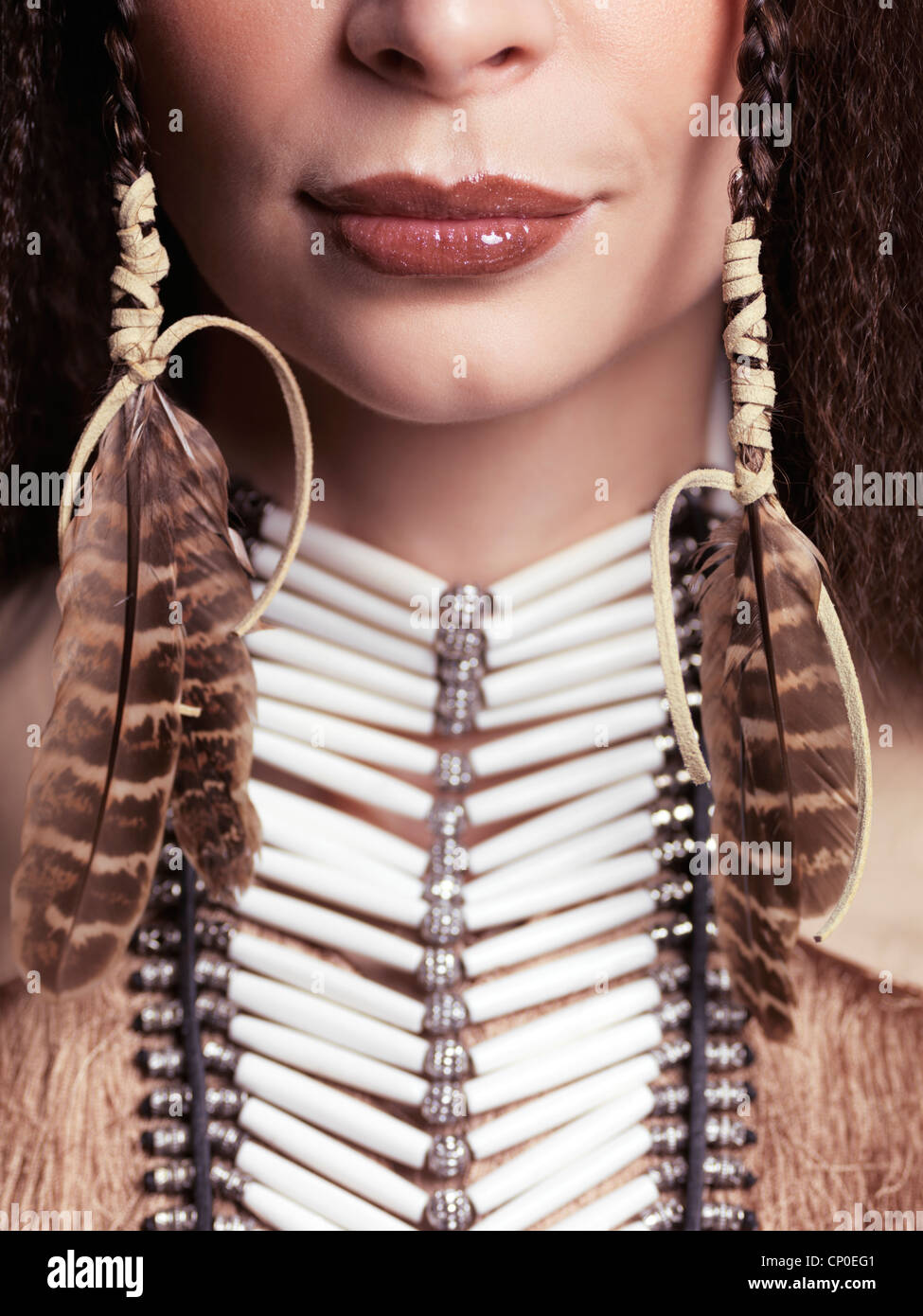Artístico closeup retrato de una mujer vistiendo los aborígenes nativos  collar accesorios y plumas en su pelo. Cerca de los labios Fotografía de  stock - Alamy