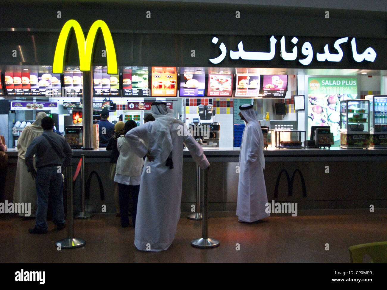 Los hombres en traje tradicional árabe en McDonalds, el aeropuerto internacional de Dubai, Dubai