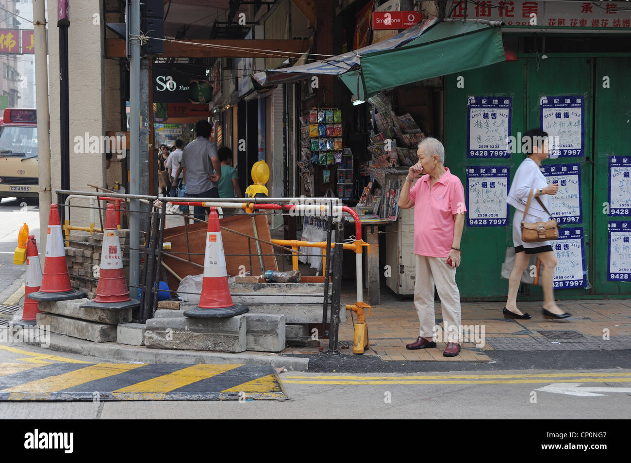 Hombre esperando para cruzar una calle, Hong Kong, China Foto de stock