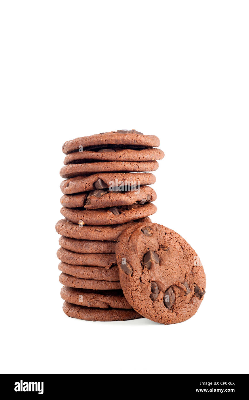 Una pila de deliciosas galletas con trocitos de chocolate oscuro con cookie primaria. Filmado en un fondo blanco para la comodidad del usuario. Foto de stock