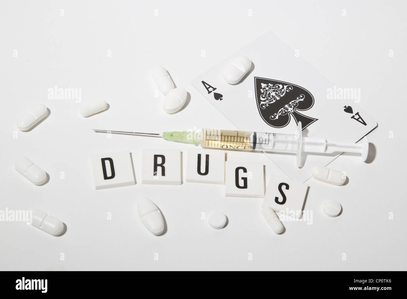 Jeringa médica con píldoras y As. Foto de stock