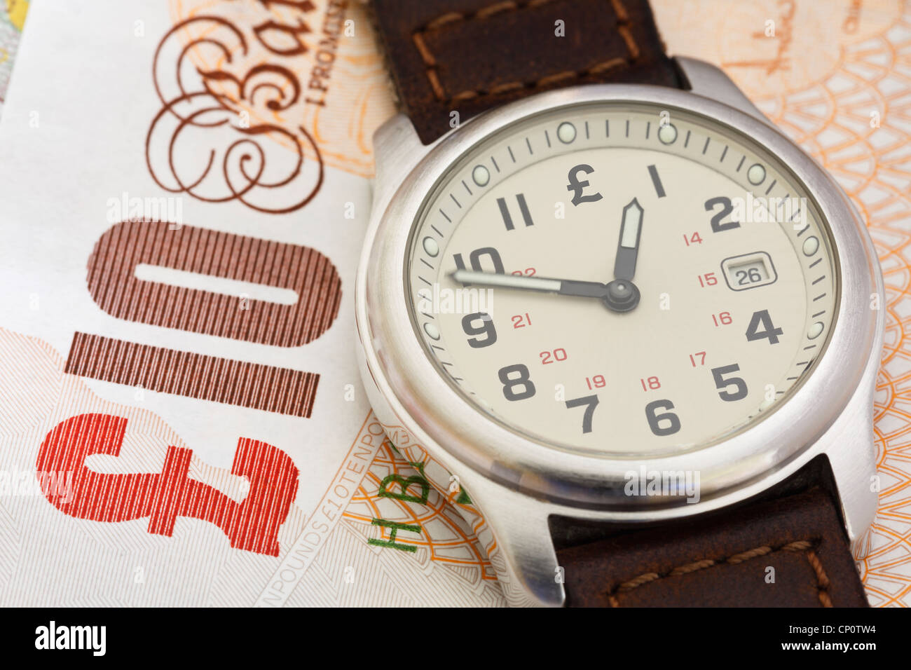 Reloj de pulsera reloj sobre una nota de diez libras esterlinas GBP para ilustrar el tiempo de poner dinero en concepto de pensión. Inglaterra, Reino Unido, Gran Bretaña Foto de stock