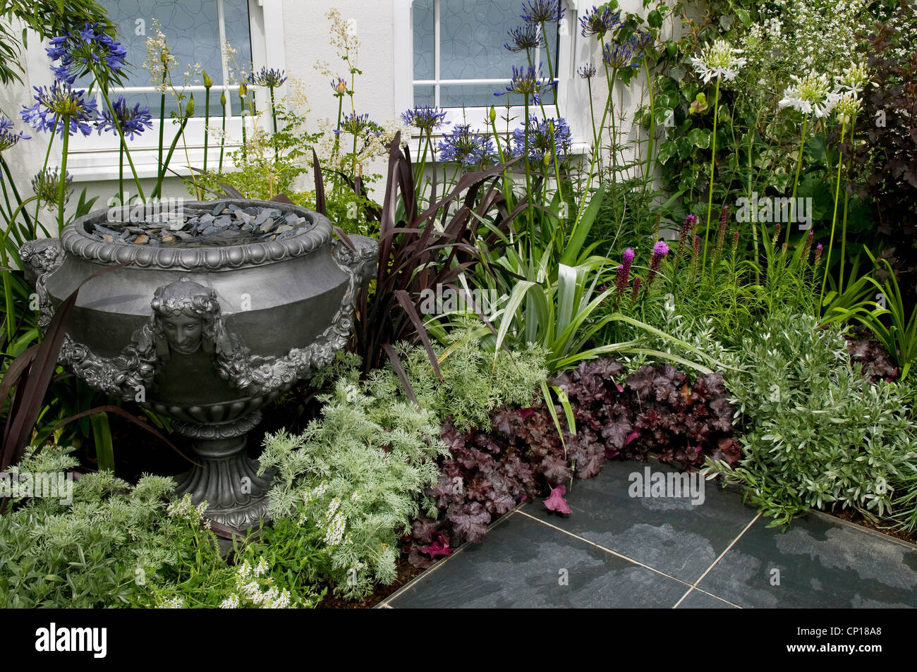 patio jardín y gran urna decorativa, norfolk, inglaterra Foto de stock