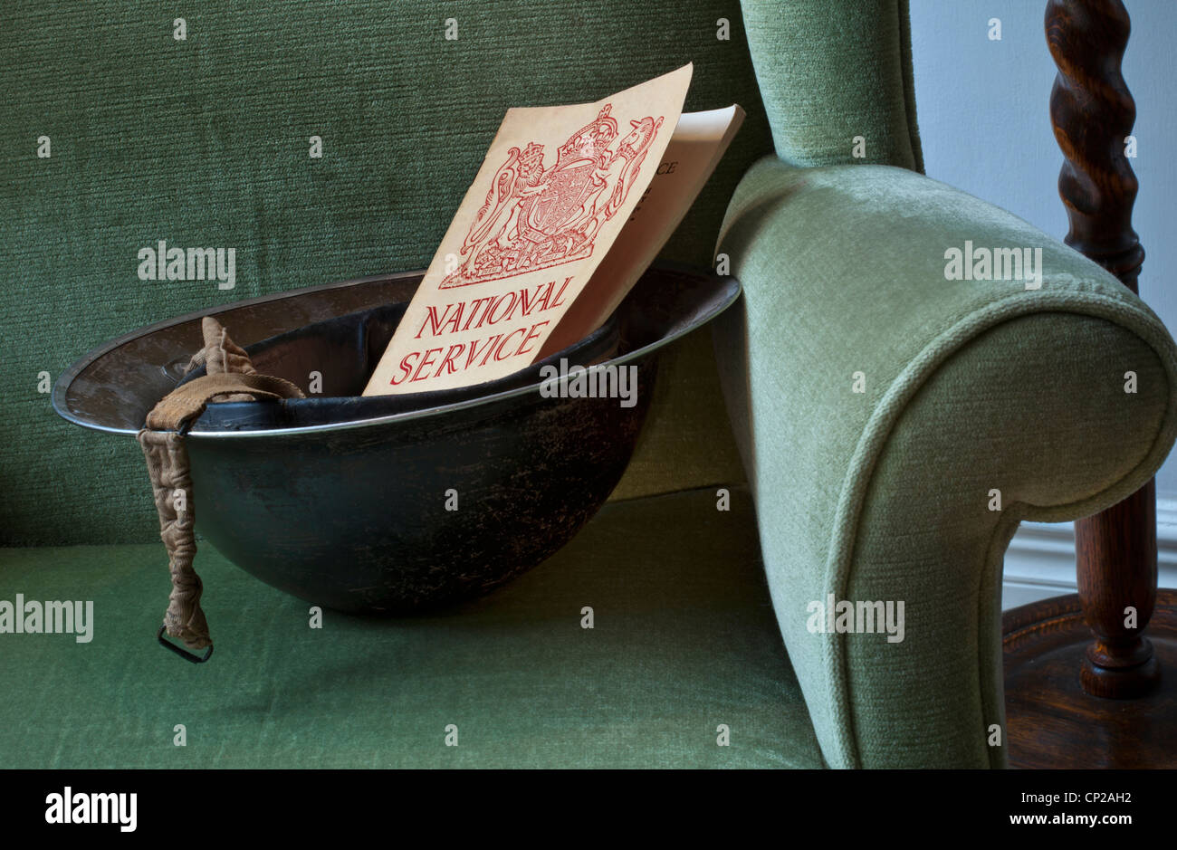 WW2 casco militar en el período silla con 1939 Servicio Nacional "llamada a las armas", folleto de voluntariado suscríbase a deberes de guerra Foto de stock